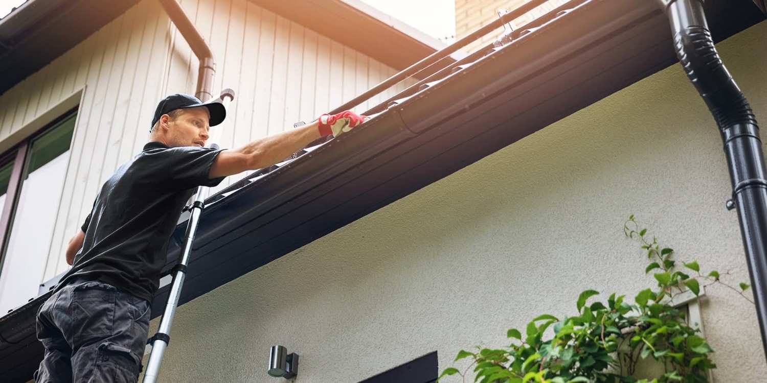 Thomson-Roof-Treatment-Staff-Removing-Clumps-of-Moss-from-Gutter